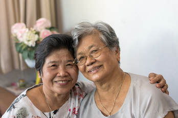 Older and younger Asian women sitting together